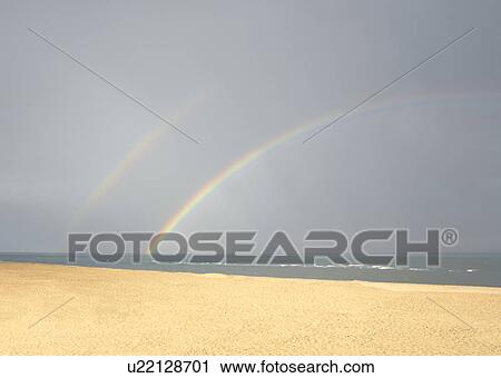 Stock Image - Beach with rainbow. Fotosearch