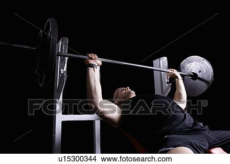Picture - bodybuilder doing bench press. Fotosearch
