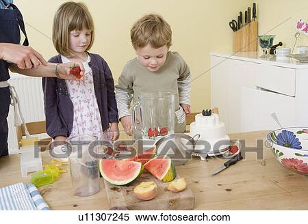 boy and girl preparing fruit smoothies View Large Photo Image Stock Photography - boy and girl preparing fruit smoothies. Fotosearch