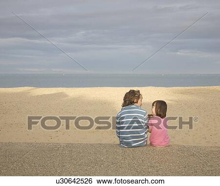 Boy and girl sitting on promenade View Large Photo Image Stock Photograph - Boy and girl sitting on promenade. Fotosearch