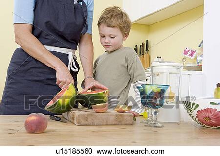 Stock Image - boy and mother preparing fruit. Fotosearch