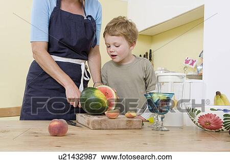 Stock Photo - boy and mother preparing fruit. Fotosearch