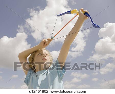 Boy firing toy bow View Large Photo Image Stock Image - Boy firing toy bow. Fotosearch