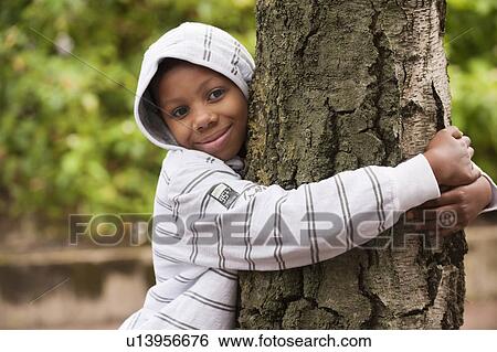 Stock Photograph - Boy hugging tree. Fotosearch