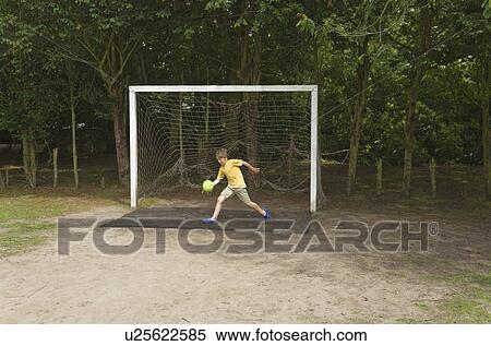 Stock Photography - Boy in goal playing football. Fotosearch