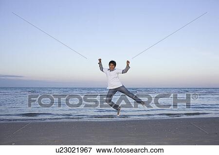 Boy jumping on the beach. View Large Photo Image Stock Photo - Boy jumping on the beach.. Fotosearch