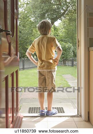 Stock Photo - Boy looking out from doorway. Fotosearch