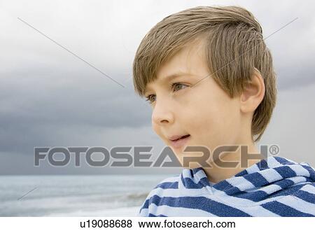 Stock Photo - Boy looking out to sea. Fotosearch