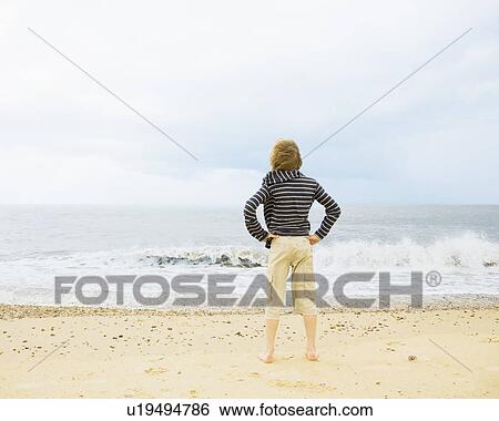 Stock Photograph - Boy looking out to sea. Fotosearch