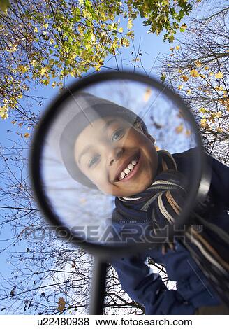 Boy looking through magnifying glass View Large Photo Image Stock Photo - Boy looking through magnifying glass. Fotosearch