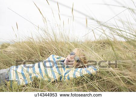 Boy lying with sunglasses in dunes View Large Photo Image Stock Image - Boy lying with sunglasses in dunes. Fotosearch