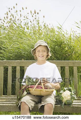 Boy on bench with vegetables View Large Photo Image Stock Photo - Boy on bench with vegetables. Fotosearch