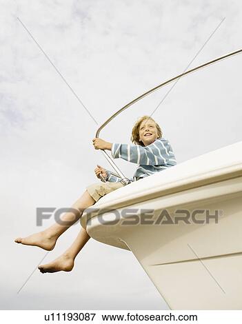Stock Photo - Boy on bow of yacht. Fotosearch