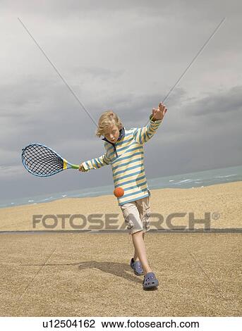 Boy playing tennis on promenade View Large Photo Image Stock Image - Boy playing tennis on promenade. Fotosearch