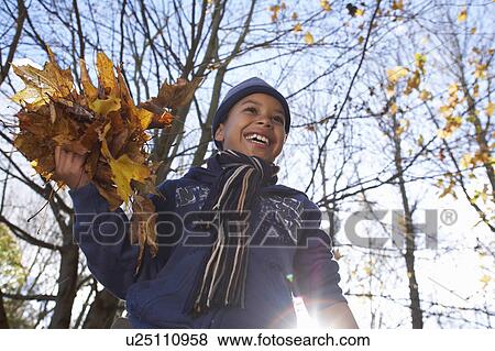 Boy playing with autumn leaves View Large Photo Image Stock Photo - Boy playing with autumn leaves. Fotosearch