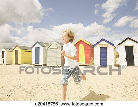 Boy running in front of beach huts View Large Photo Image Stock Photograph - Boy running in front of beach huts. Fotosearch