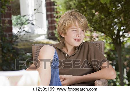 Stock Photo - boy sitting in chair. Fotosearch