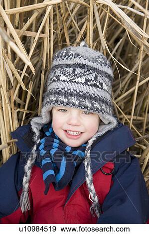 Boy sitting in straw View Large Photo Image Stock Photo - Boy sitting in straw. Fotosearch