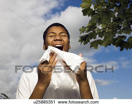 Stock Image - boy sneezing outside. Fotosearch