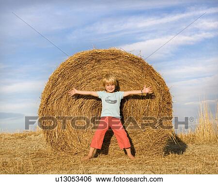 boy standing in front of hay bale View Large Photo Image Stock Photograph - boy standing in front of hay bale. Fotosearch