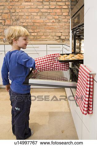 boy taking baked cookies from oven View Large Photo Image Stock Photo - boy taking baked cookies from oven. Fotosearch