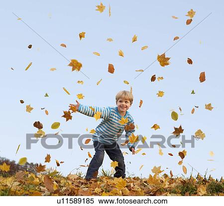 boy throwing autumn leaves into the air View Large Photo Image Stock Photography - boy throwing autumn leaves into the air. Fotosearch