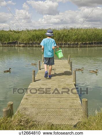 Boy walking on jetty View Large Photo Image Stock Image - Boy walking on jetty. Fotosearch