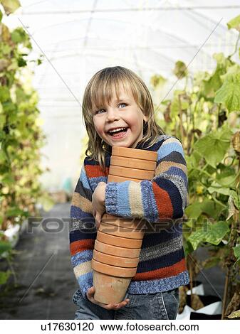 Boy with flower pots in green house View Large Photo Image Stock Image - Boy with flower pots in green house. Fotosearch