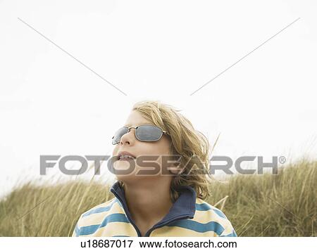 Stock Photo - Boy with sunglasses in dunes. Fotosearch