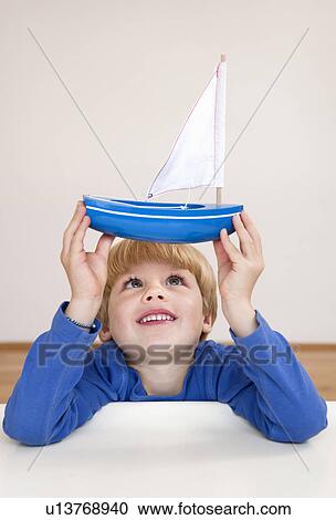 Stock Image - boy with toy boat. Fotosearch