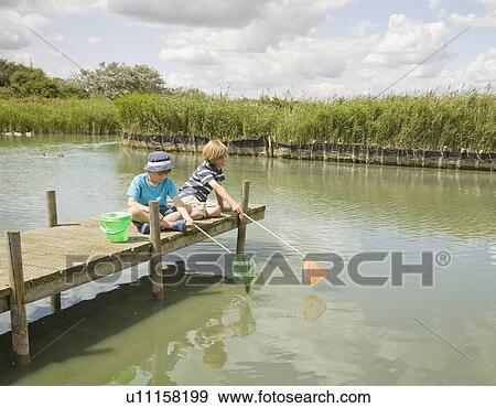 Boys fishing off jetty View Large Photo Image Stock Photo - Boys fishing off jetty. Fotosearch