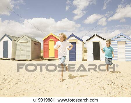 Boys running in front of beach huts View Large Photo Image Stock Image - Boys running in front of beach huts. Fotosearch