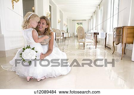 Picture - bride with young flower girl talk. Fotosearch