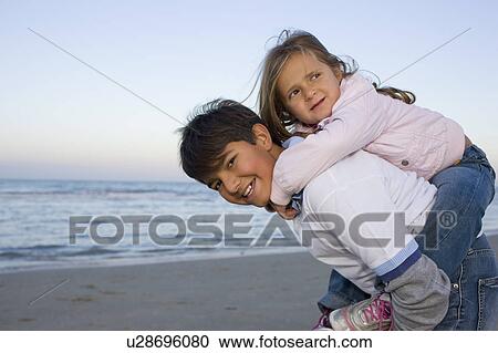 Stock Image - Brother and sister on the beach.. Fotosearch