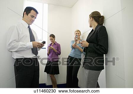 Business colleagues on their phones View Large Photo Image Stock Image - Business colleagues on their phones. Fotosearch