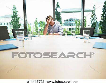 Stock Image - Business man in a empty conference room. Fotosearch