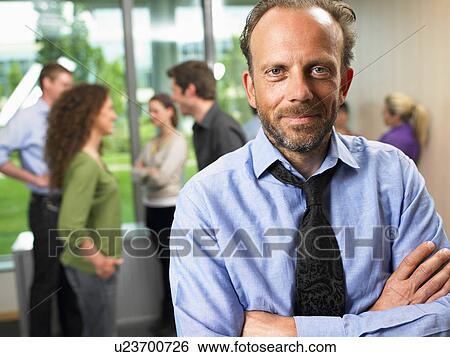 Stock Photograph - Business man in the office, smiling. Fotosearch