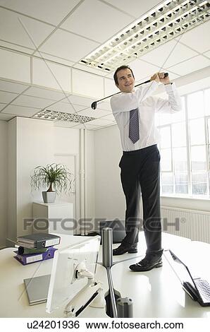 Stock Photograph - Business man playing golf. Fotosearch