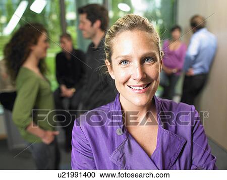 Stock Image - Business woman in the office, smiling. Fotosearch