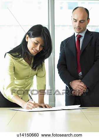 Stock Image - Business woman signing a contract. Fotosearch