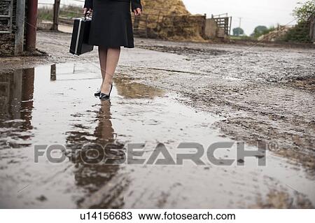 business woman walking at muddy farm View Large Photo Image Stock Image - business woman walking at muddy farm. Fotosearch