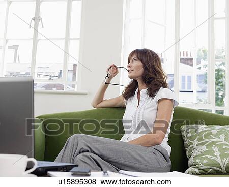 Stock Photo - Business women contemplating on sofa. Fotosearch