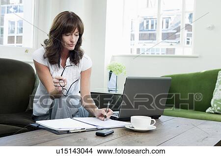 Picture - Business women looking at papers on sofa. Fotosearch