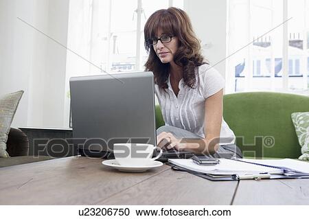 Business women working on laptop on sofa View Large Photo Image Stock Image - Business women working on laptop on sofa. Fotosearch