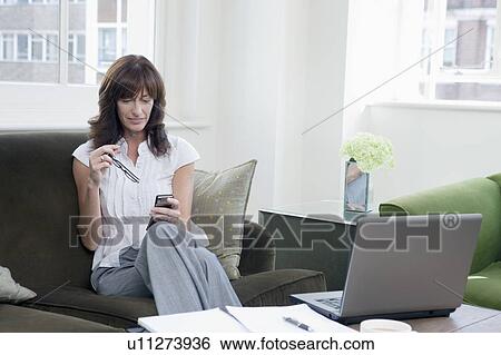 Stock Photograph - Business women working on mobile phone. Fotosearch
