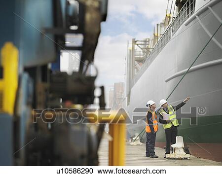 Stock Image - Businessman And Port Worker With Ship. Fotosearch