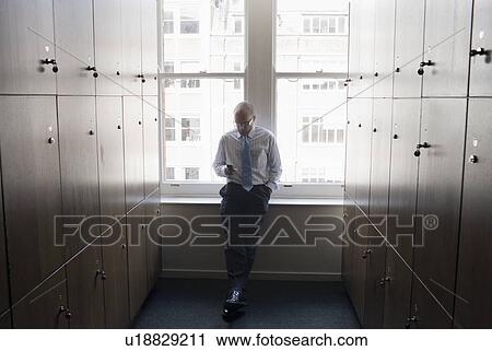 Businessman in a locker room View Large Photo Image Stock Image - Businessman in a locker room. Fotosearch