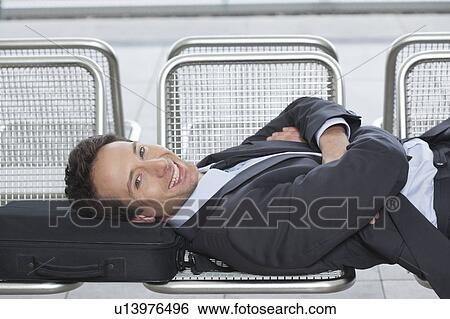 Stock Photograph - businessman lying on bench, happy. Fotosearch
