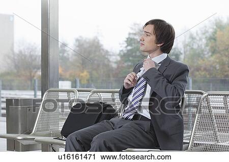 businessman on bench, adjusting tie View Large Photo Image Stock Image - businessman on bench, adjusting tie. Fotosearch