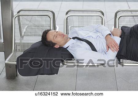 Stock Image - businessman on bench, eyes closed. Fotosearch